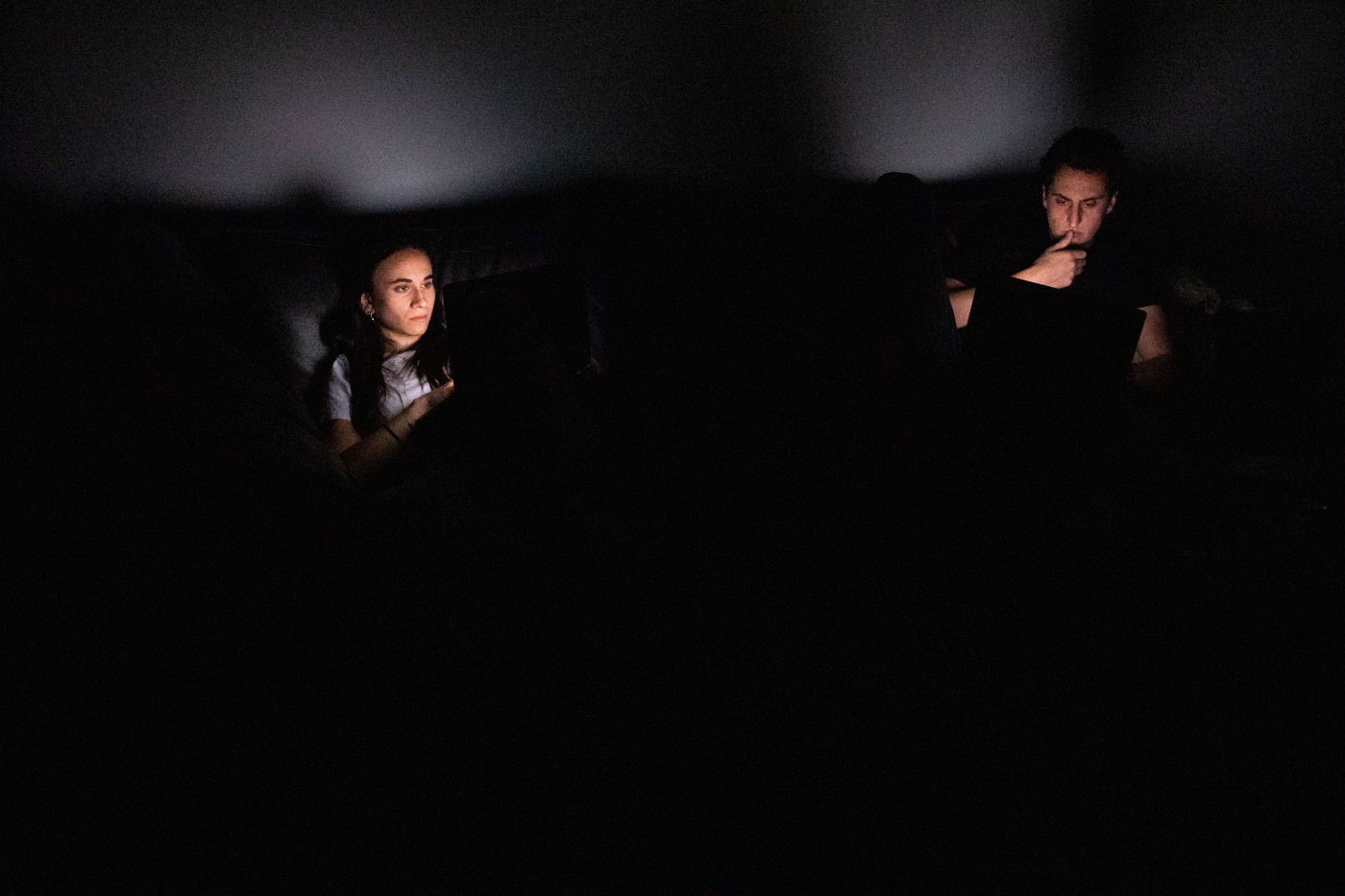 2 people sitting apart with dramatic lighting